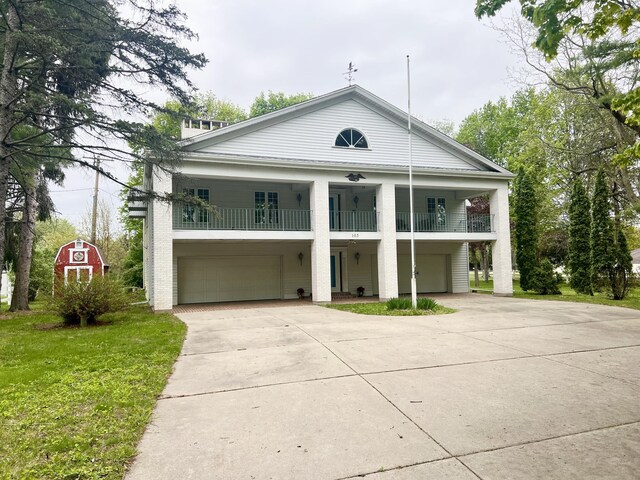 103 Lukesport Dr, Quincy, MI 49082 - neoclassical / greek revival house featuring a balcony, an attached garage, concrete driveway, and a front yard