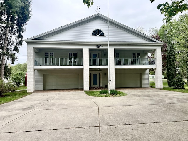 103 Lukesport Dr, Quincy, MI 49082 - neoclassical home with a balcony, an attached garage, driveway, and brick siding