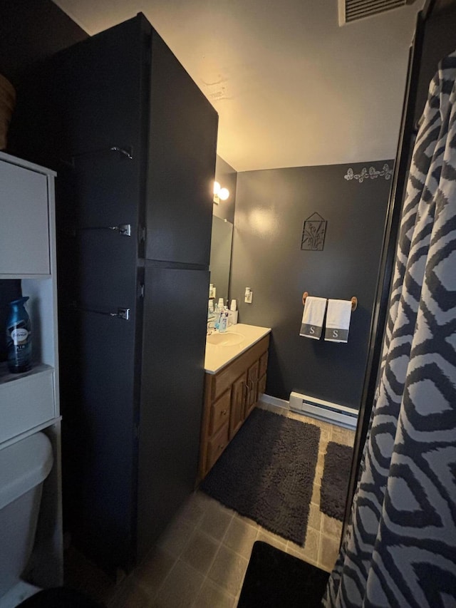 410 S Union St, Hart, MI 49420 - bathroom featuring a baseboard radiator, vanity, tile patterned flooring, toilet, and a shower with curtain