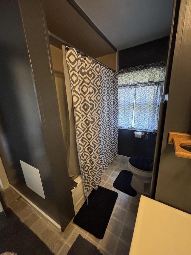 410 S Union St, Hart, MI 49420 - bathroom featuring a shower with curtain, tile patterned flooring, and toilet