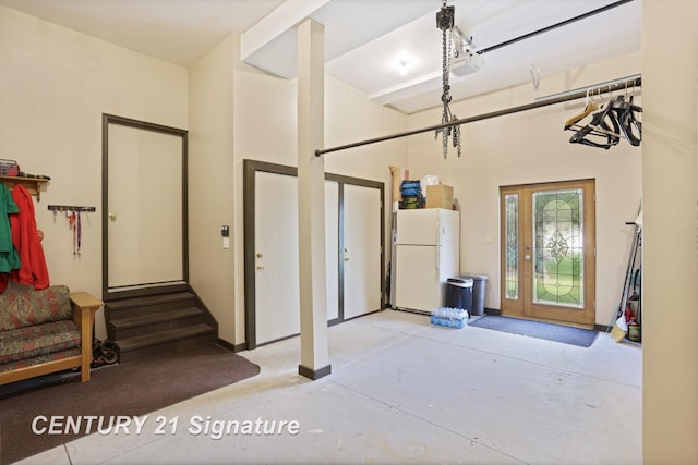 730 S Point Rd, Gladwin, MI 48624 - garage with freestanding refrigerator and a garage door opener