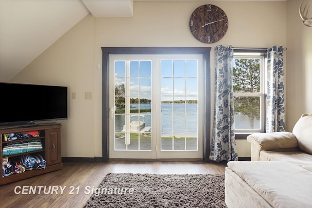 730 S Point Rd, Gladwin, MI 48624 - living room featuring wood finished floors, lofted ceiling, a water view, and baseboards
