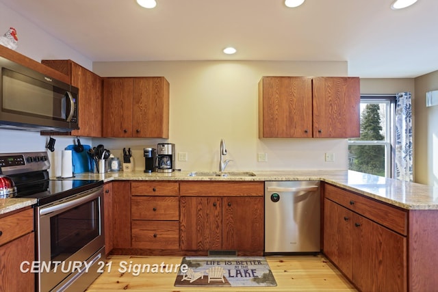 730 S Point Rd, Gladwin, MI 48624 - kitchen featuring appliances with stainless steel finishes, a sink, a peninsula, recessed lighting, and light stone countertops