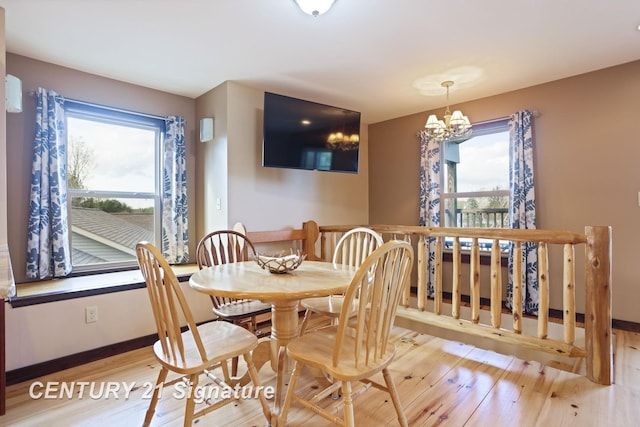 730 S Point Rd, Gladwin, MI 48624 - dining area with wood finished floors, baseboards, and a chandelier