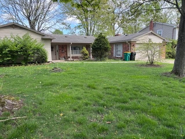 25370 Chapelweigh Dr, Farmington Hills, MI 48336 - view of front facade with a front lawn, brick siding, and an attached garage