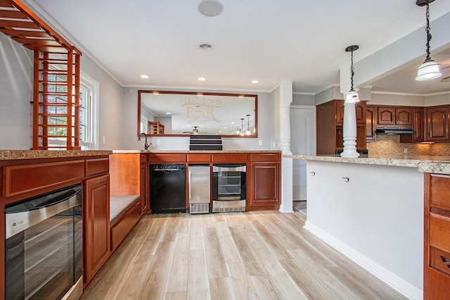 1507 Pinehurst Ln, Niles, MI 49120 - kitchen featuring beverage cooler, under cabinet range hood, ornamental molding, light wood-style flooring, and ornate columns