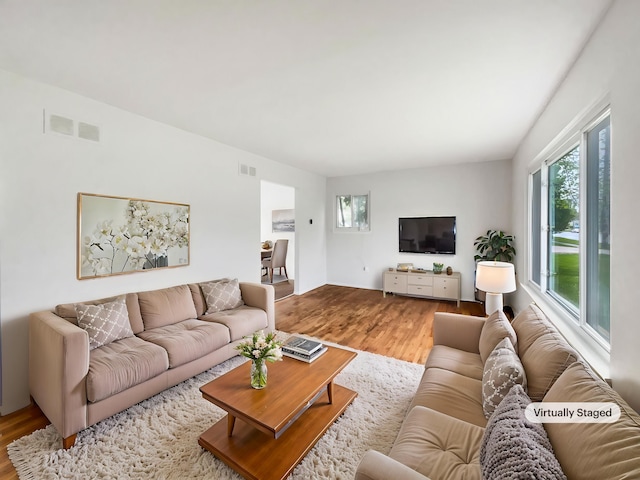 living room with plenty of natural light and wood finished floors
