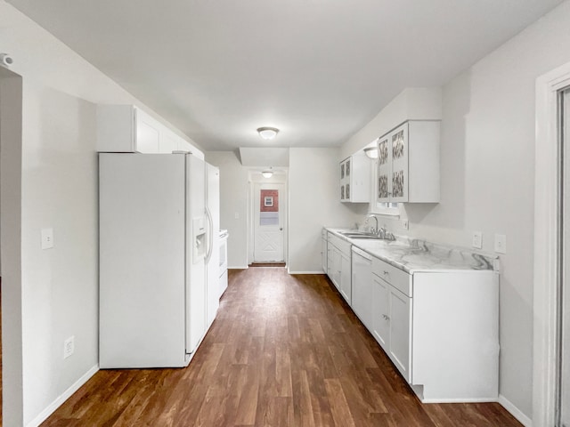 kitchen with white appliances, a sink, dark wood-style flooring, light countertops, and white cabinetry