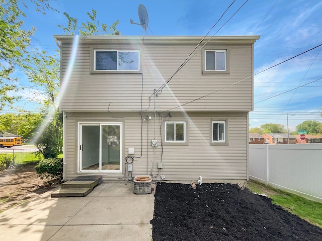 back of property with fence and a patio