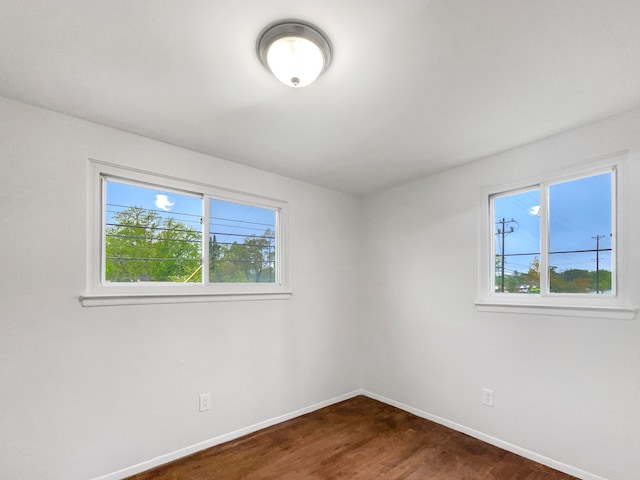 empty room with baseboards and dark wood finished floors