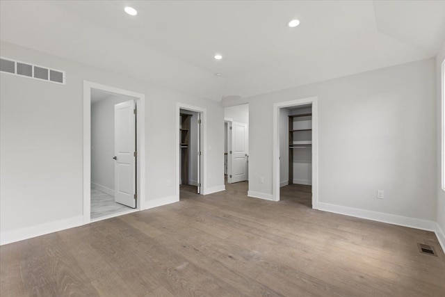 3408 Eastern Ave, Rochester Hills, MI 48307 - unfurnished bedroom with a walk in closet, baseboards, recessed lighting, wood finished floors, and a closet