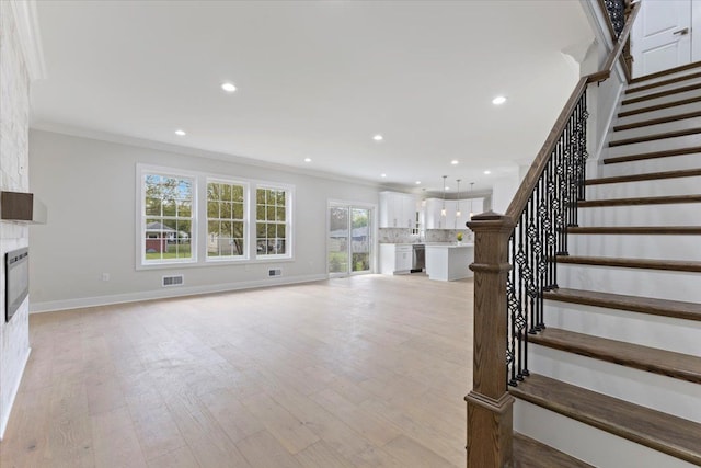 3408 Eastern Ave, Rochester Hills, MI 48307 - unfurnished living room featuring crown molding, stairway, light wood-style flooring, recessed lighting, and baseboards