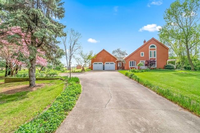 view of front facade with driveway, a front lawn, a garage, and a chimney