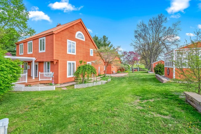 back of property with a yard and a wooden deck
