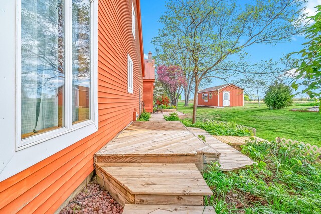 wooden deck with a lawn and an outdoor structure