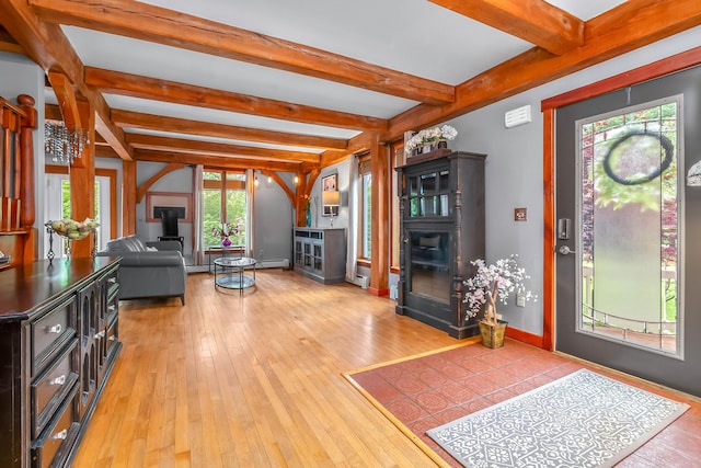 living area featuring beam ceiling, hardwood / wood-style floors, a fireplace, baseboards, and a baseboard radiator