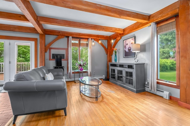 living area with a wood stove, a baseboard radiator, beam ceiling, and hardwood / wood-style floors