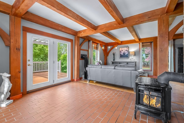 living room featuring beam ceiling, a wood stove, and coffered ceiling