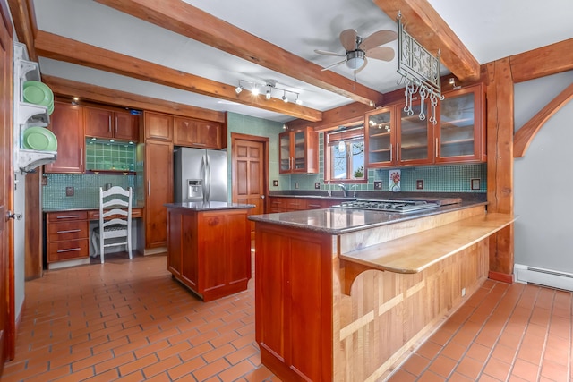 kitchen featuring appliances with stainless steel finishes, beamed ceiling, backsplash, a peninsula, and glass insert cabinets