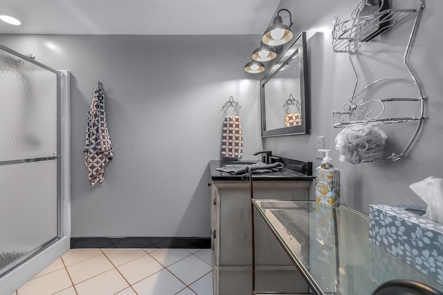bathroom with tile patterned flooring, a shower stall, and vanity