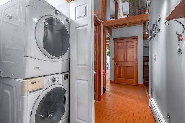 laundry room featuring stacked washing machine and dryer, baseboard heating, brick floors, and baseboards