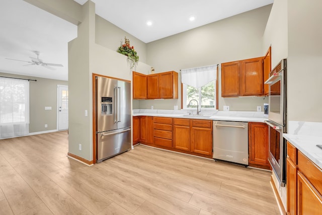 4953 Clintonville Rd, Clarkston, MI 48346 - kitchen with stainless steel appliances, a sink, a high ceiling, light countertops, and brown cabinetry
