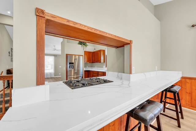 4953 Clintonville Rd, Clarkston, MI 48346 - kitchen featuring stainless steel refrigerator with ice dispenser, black gas stovetop, light wood-type flooring, a peninsula, and wainscoting