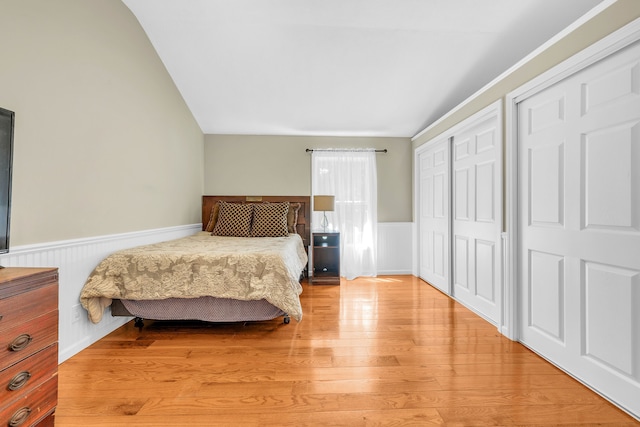 4953 Clintonville Rd, Clarkston, MI 48346 - bedroom with lofted ceiling, a wainscoted wall, and light wood-style floors