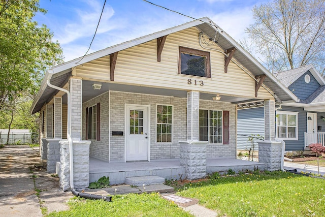 view of front of property with covered porch and a front lawn