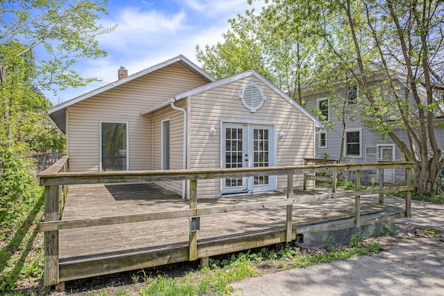 back of house with french doors, a chimney, and a deck