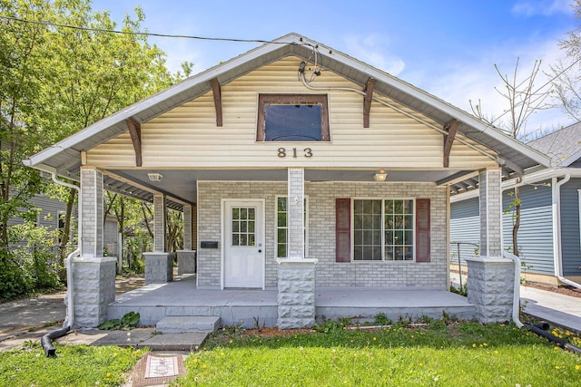 view of front of home featuring a porch and brick siding