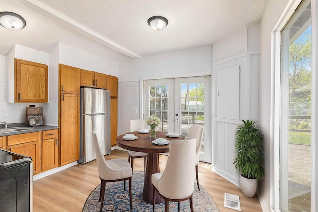 dining room with french doors and light wood-style flooring