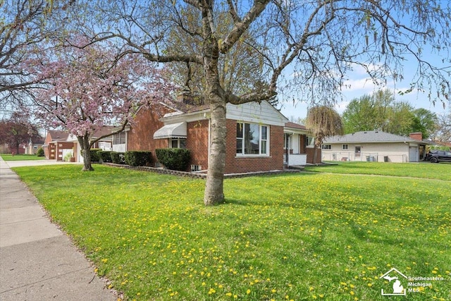 view of front of property with brick siding, a front yard, and driveway
