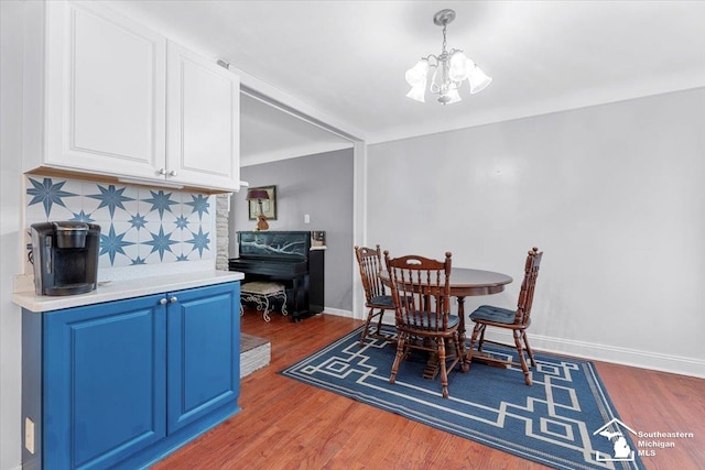 dining room featuring a chandelier, wood finished floors, and baseboards