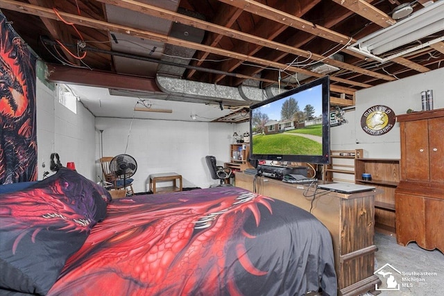 bedroom with unfinished concrete flooring and concrete block wall