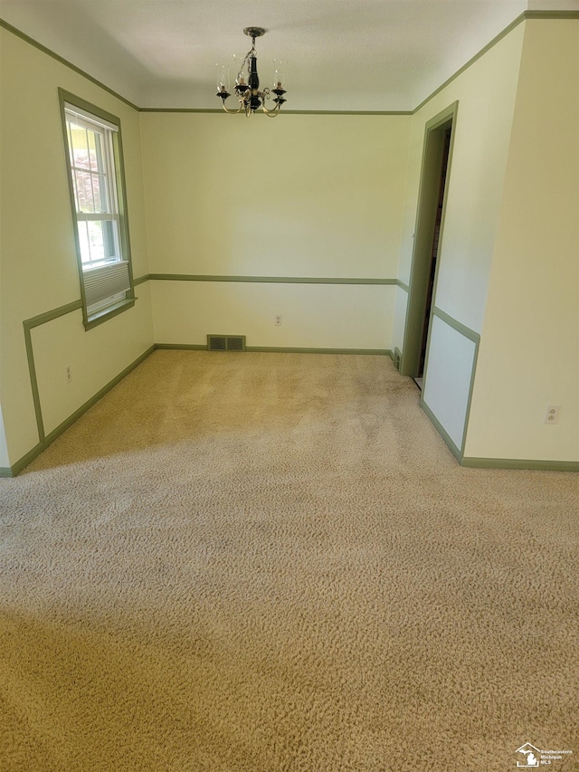 spare room with a chandelier, baseboards, and light colored carpet
