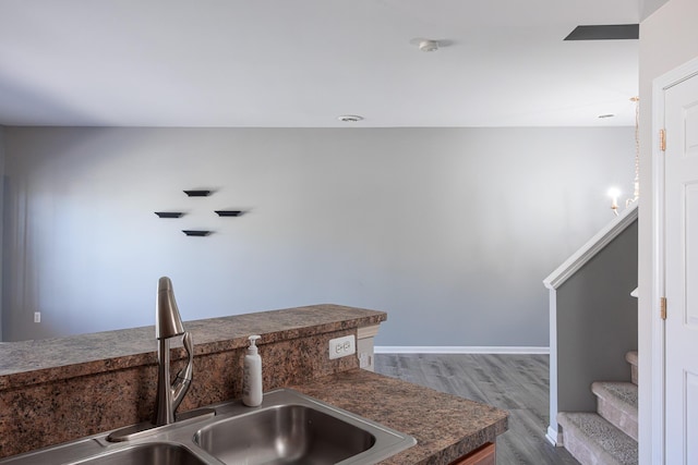 3050 Cloverly Ln, Ann Arbor, MI 48108 - kitchen with a sink, wood finished floors, dark countertops, and baseboards