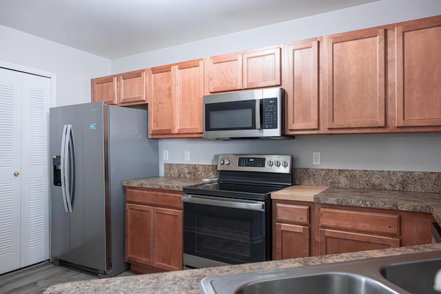 3050 Cloverly Ln, Ann Arbor, MI 48108 - kitchen with appliances with stainless steel finishes, wood finished floors, and a sink