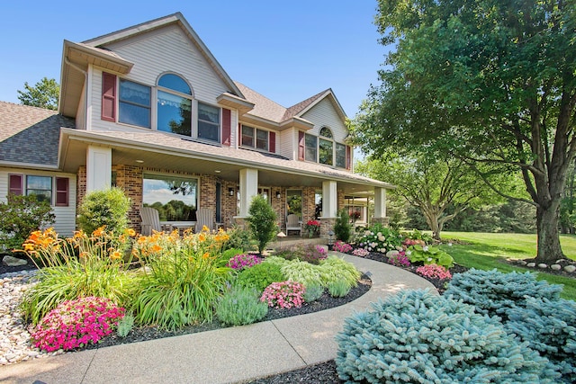 9695 36th St S, Scotts, MI 49088 - view of front facade featuring a porch, a shingled roof, and brick siding