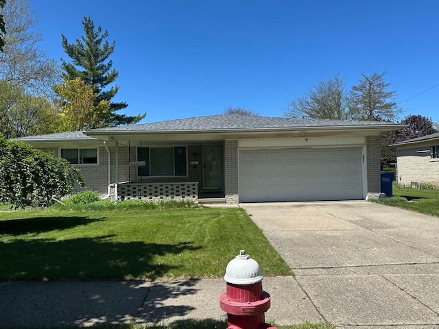 ranch-style home featuring brick siding, a front lawn, an attached garage, and concrete driveway