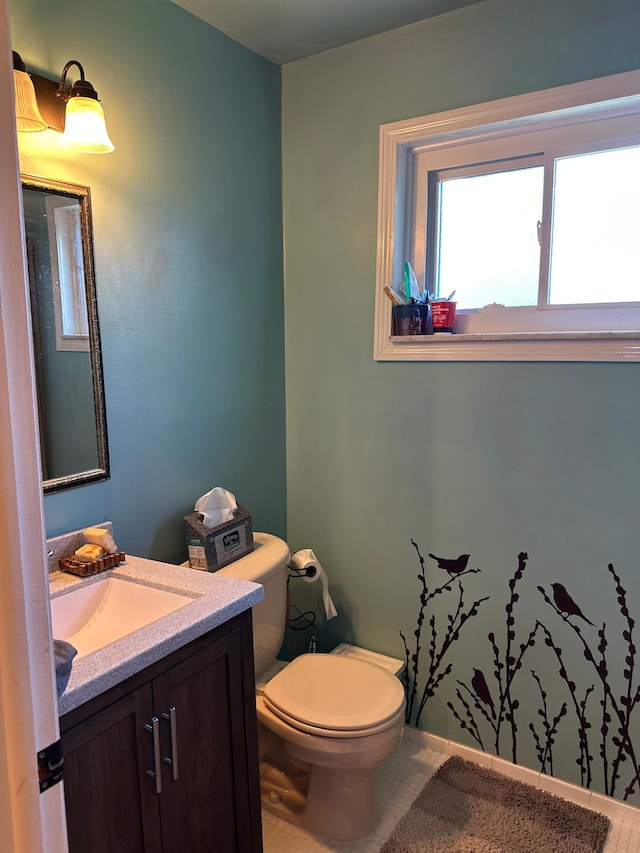 bathroom featuring toilet, vanity, and tile patterned flooring