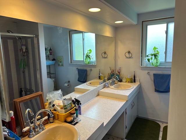 bathroom featuring a sink, a stall shower, plenty of natural light, and recessed lighting