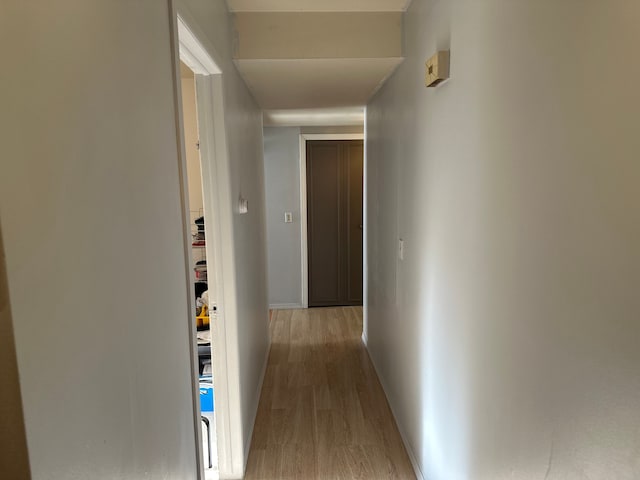 hall featuring baseboards and wood finished floors