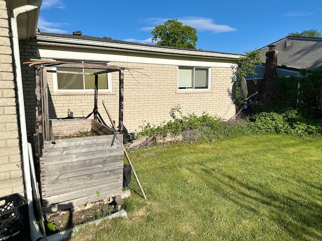 view of property exterior featuring brick siding and a lawn