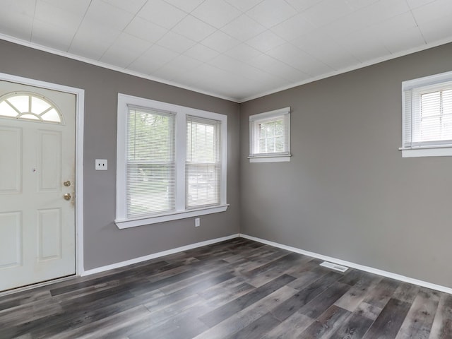 foyer entrance with crown molding, dark wood-type flooring, and baseboards