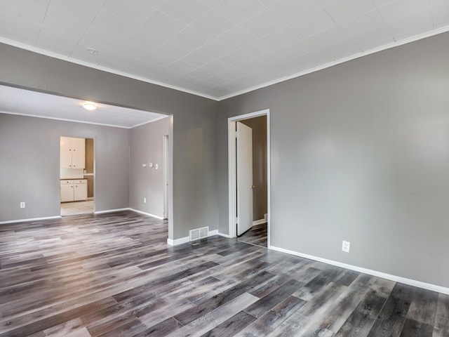unfurnished room with crown molding, wood finished floors, and baseboards