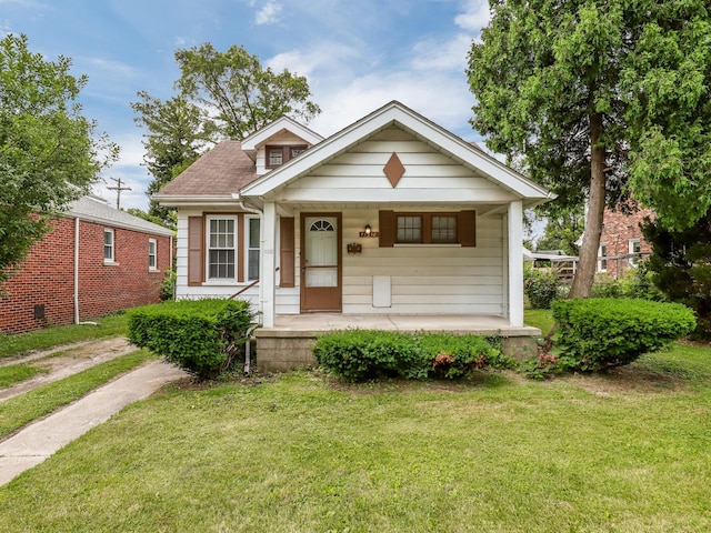 bungalow featuring a porch and a front lawn