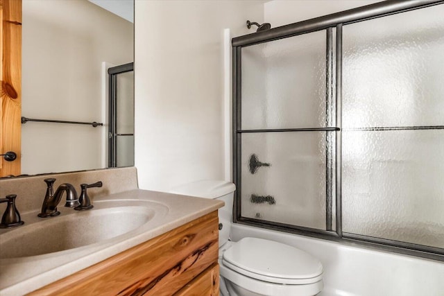 80220 Linden Hills St, Covert, MI 49043 - bathroom featuring toilet, vanity, and bath / shower combo with glass door