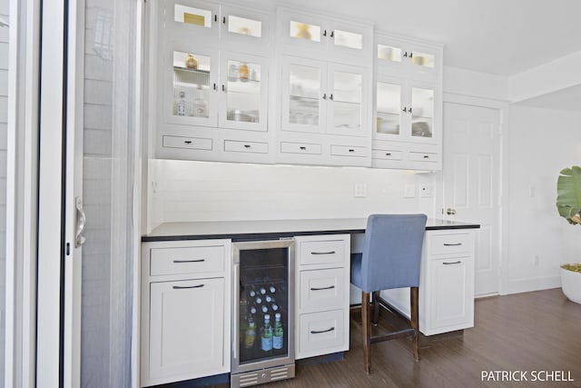 office featuring wine cooler, dark wood-type flooring, and built in study area