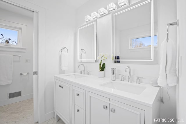 full bathroom featuring double vanity and baseboards